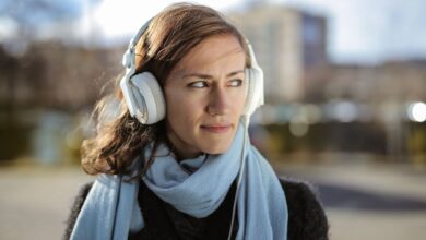 Person wearing headphones listening to audio content on a smartphone