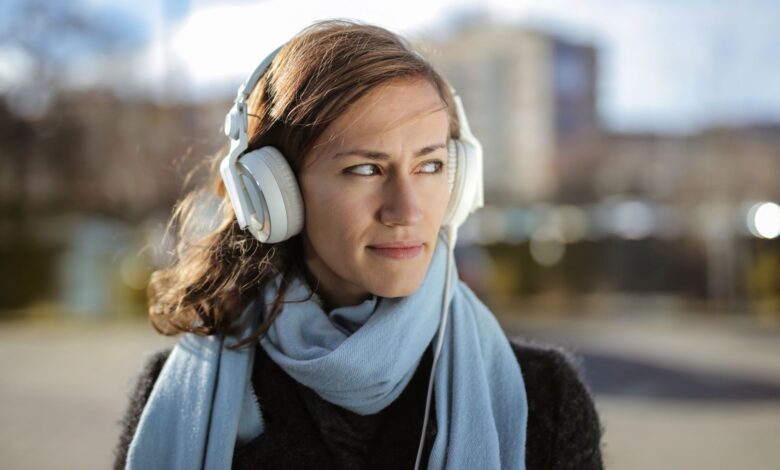 Person wearing headphones listening to audio content on a smartphone