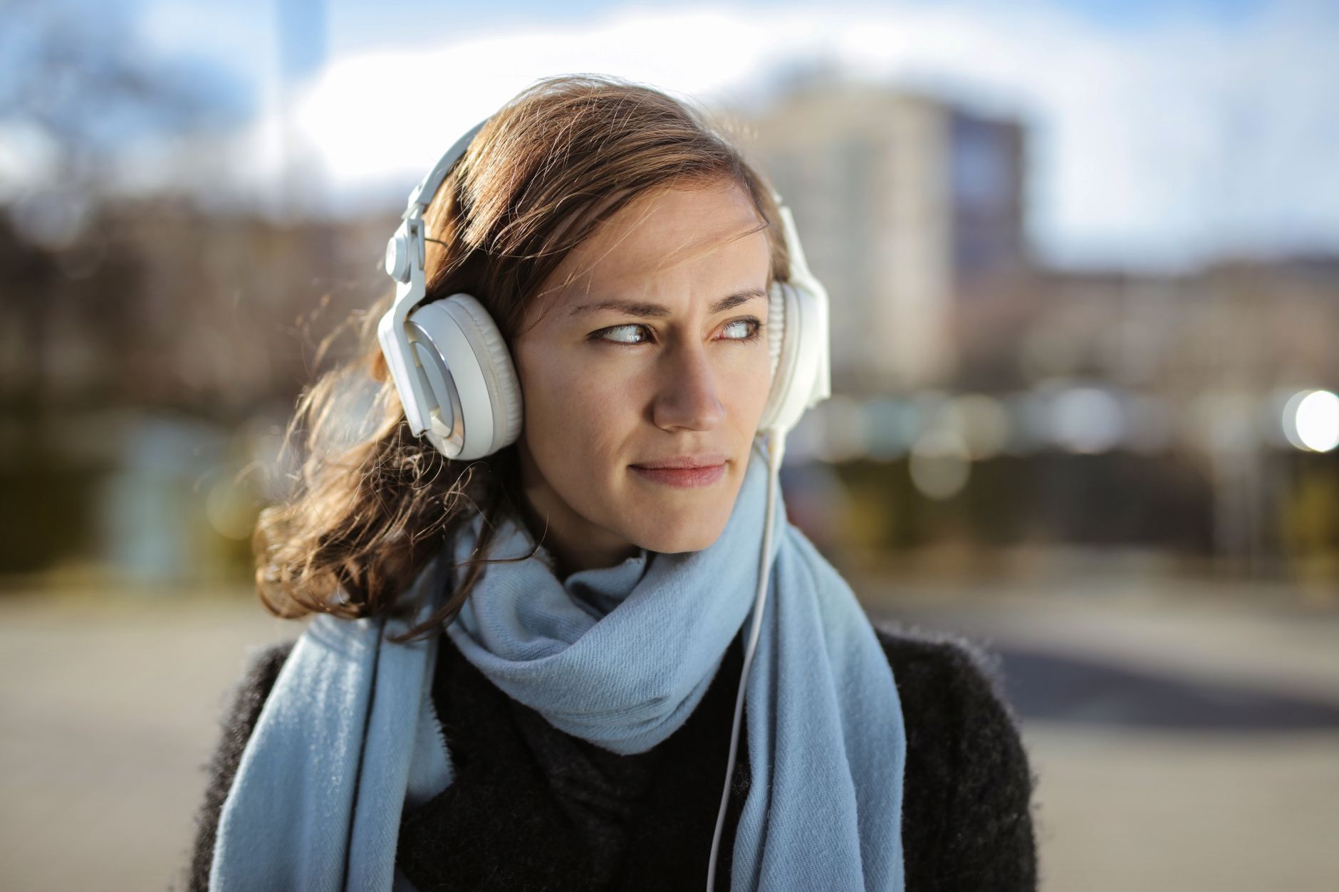 Person wearing headphones listening to audio content on a smartphone