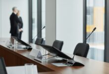 Empty corporate boardroom with chairs around a long conference table, representing organizational governance decisions