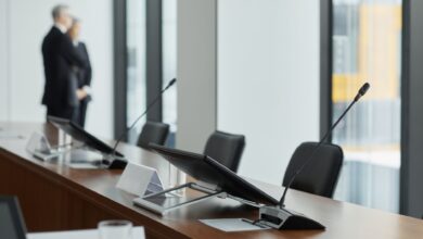 Empty corporate boardroom with chairs around a long conference table, representing organizational governance decisions