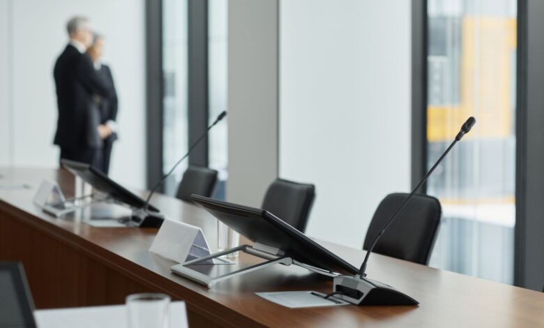 Empty corporate boardroom with chairs around a long conference table, representing organizational governance decisions