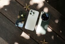 Row of iPhones displayed on a table showing different models side by side