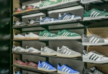 Athletic sneakers displayed on a retail store wall with organized shelving