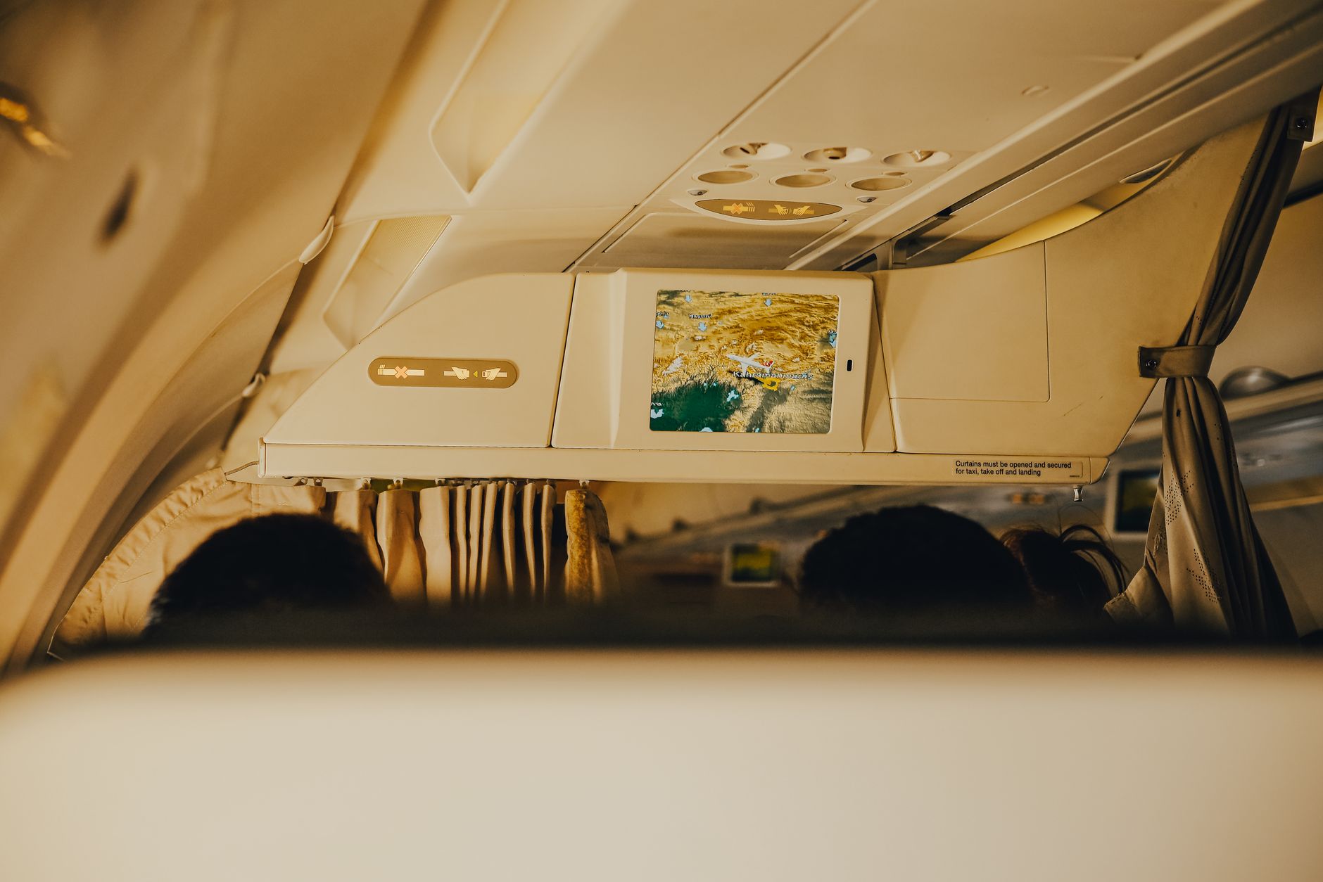 Business class cabin interior showing premium airline seats with personal screens