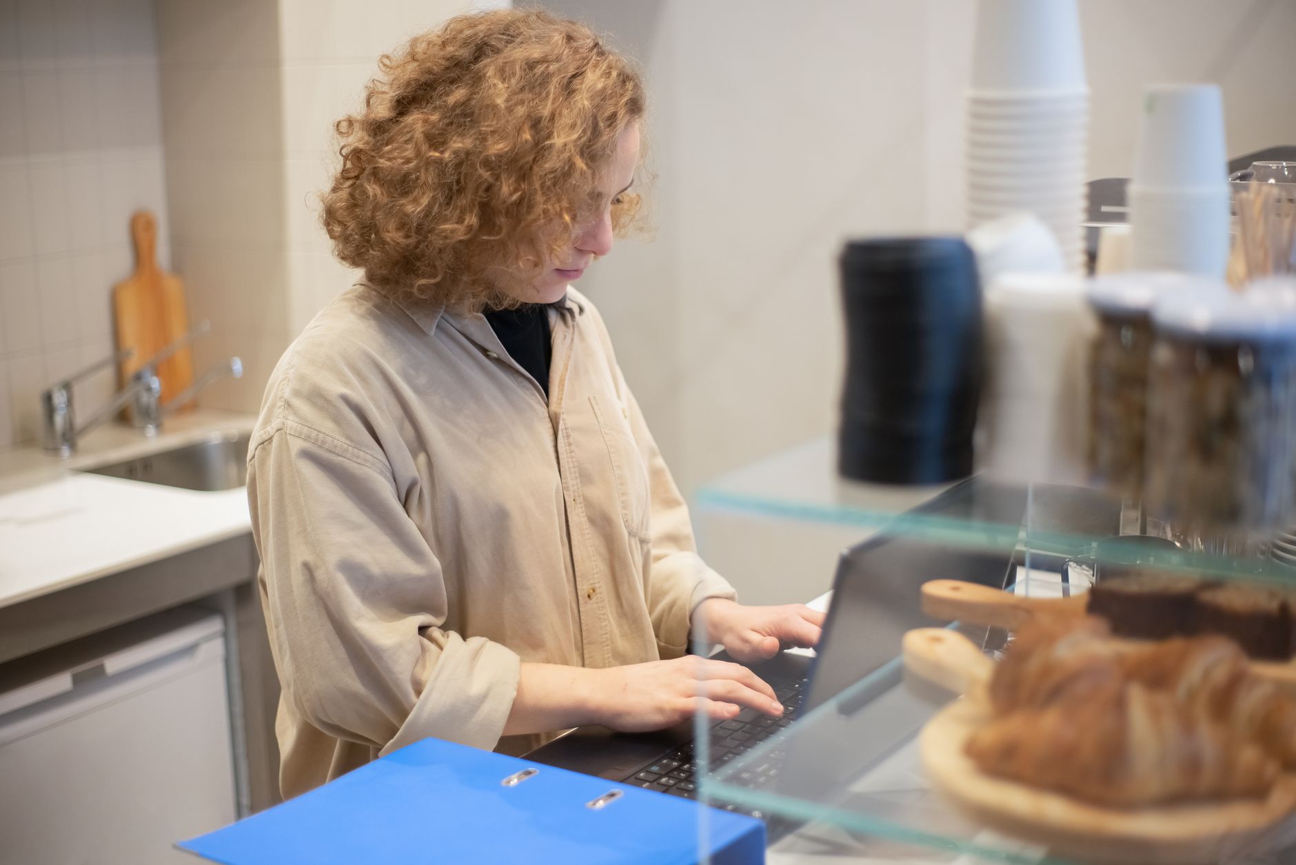 Coffee shop worker managing multiple orders during a morning rush