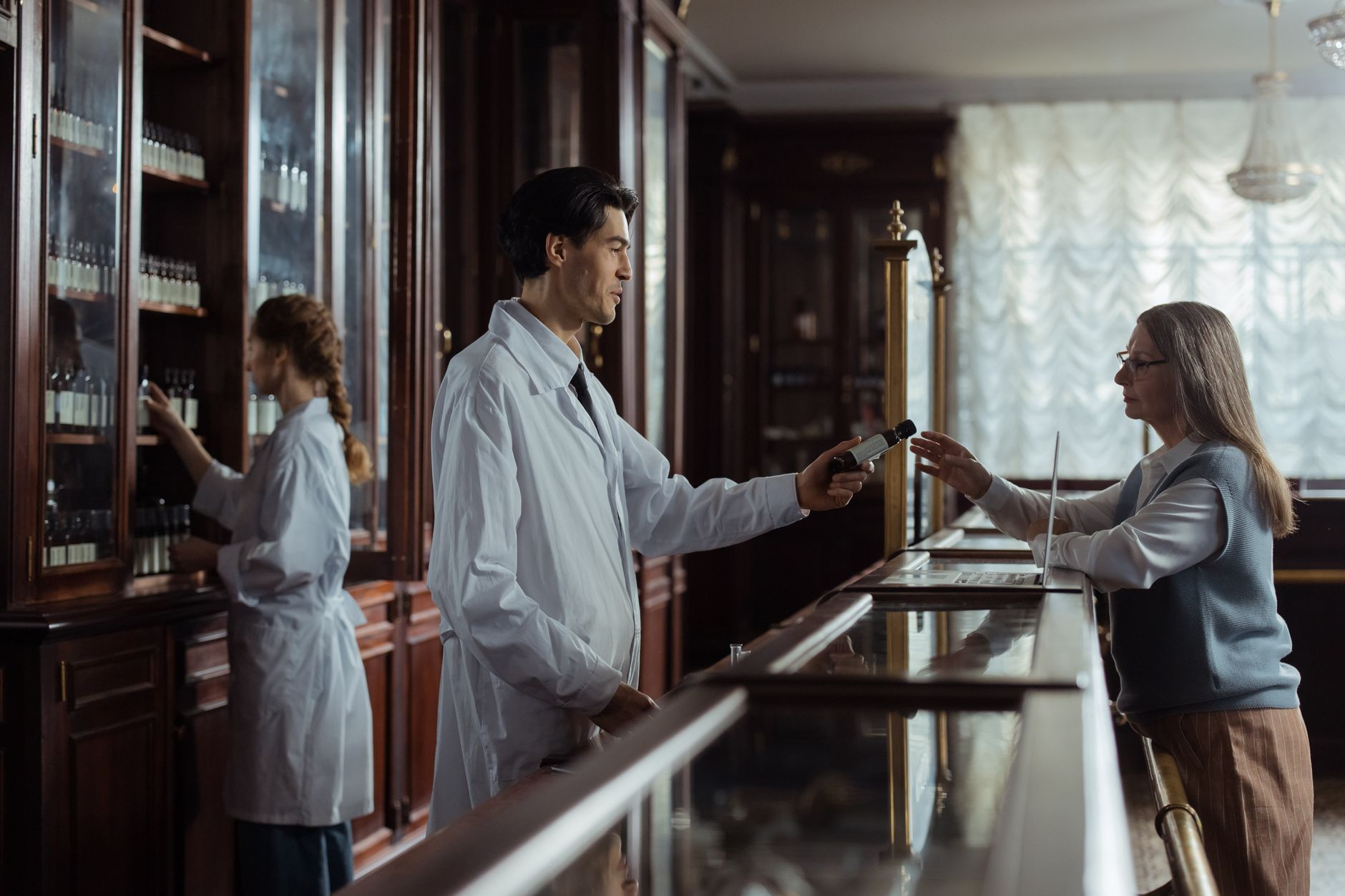 Pharmacist at a counter filling prescriptions, illustrating drug supply and availability challenges