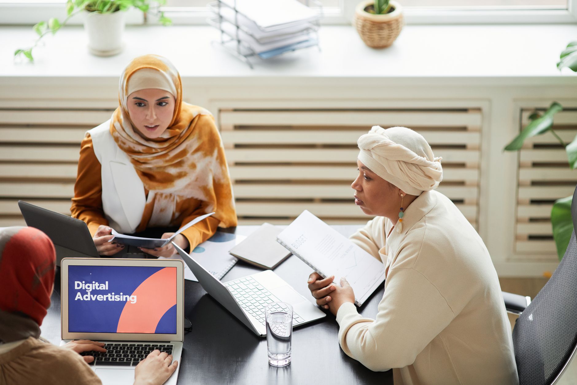 Marketing team reviewing digital advertising campaign performance on monitors