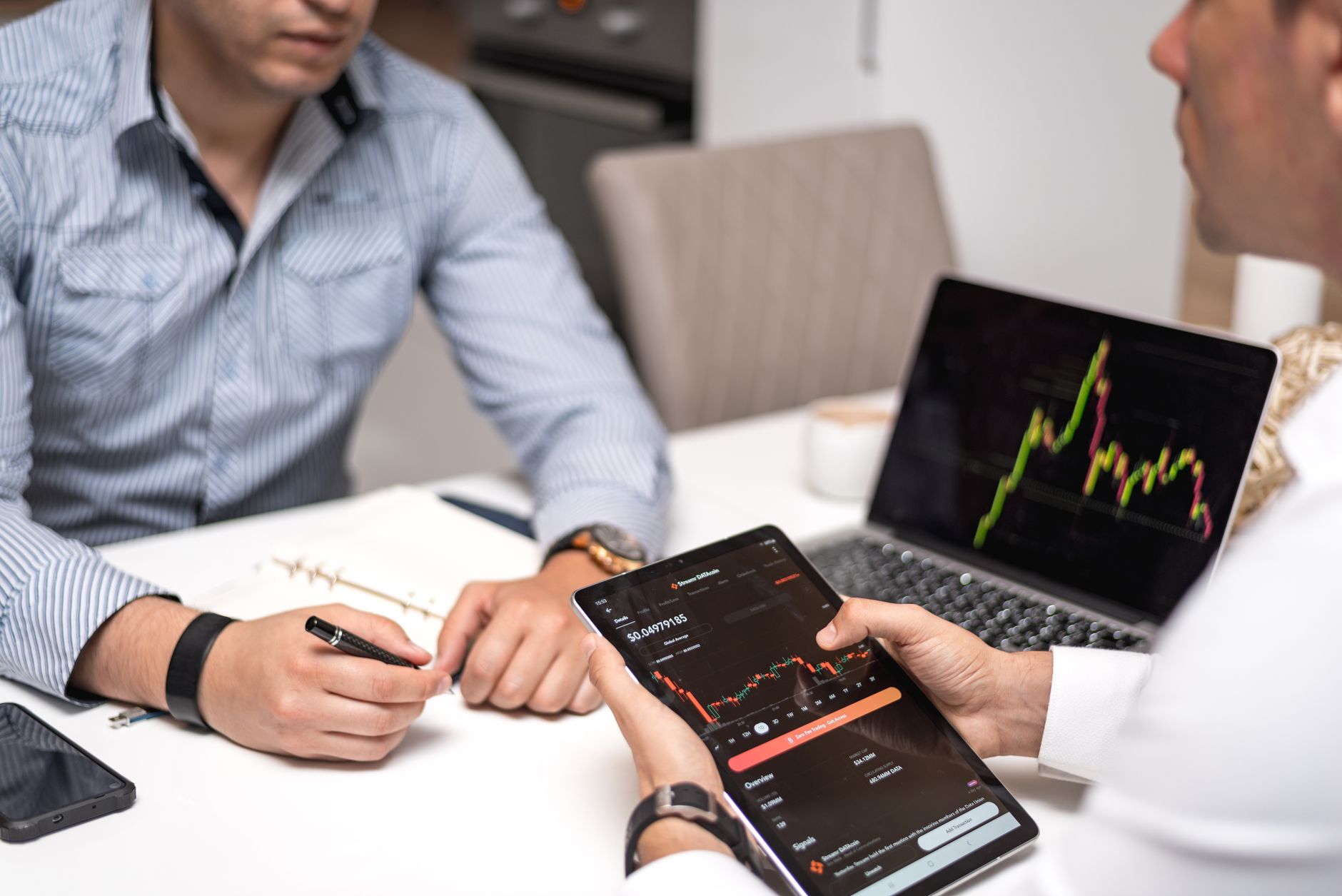 Business professionals reviewing financial technology data on laptops