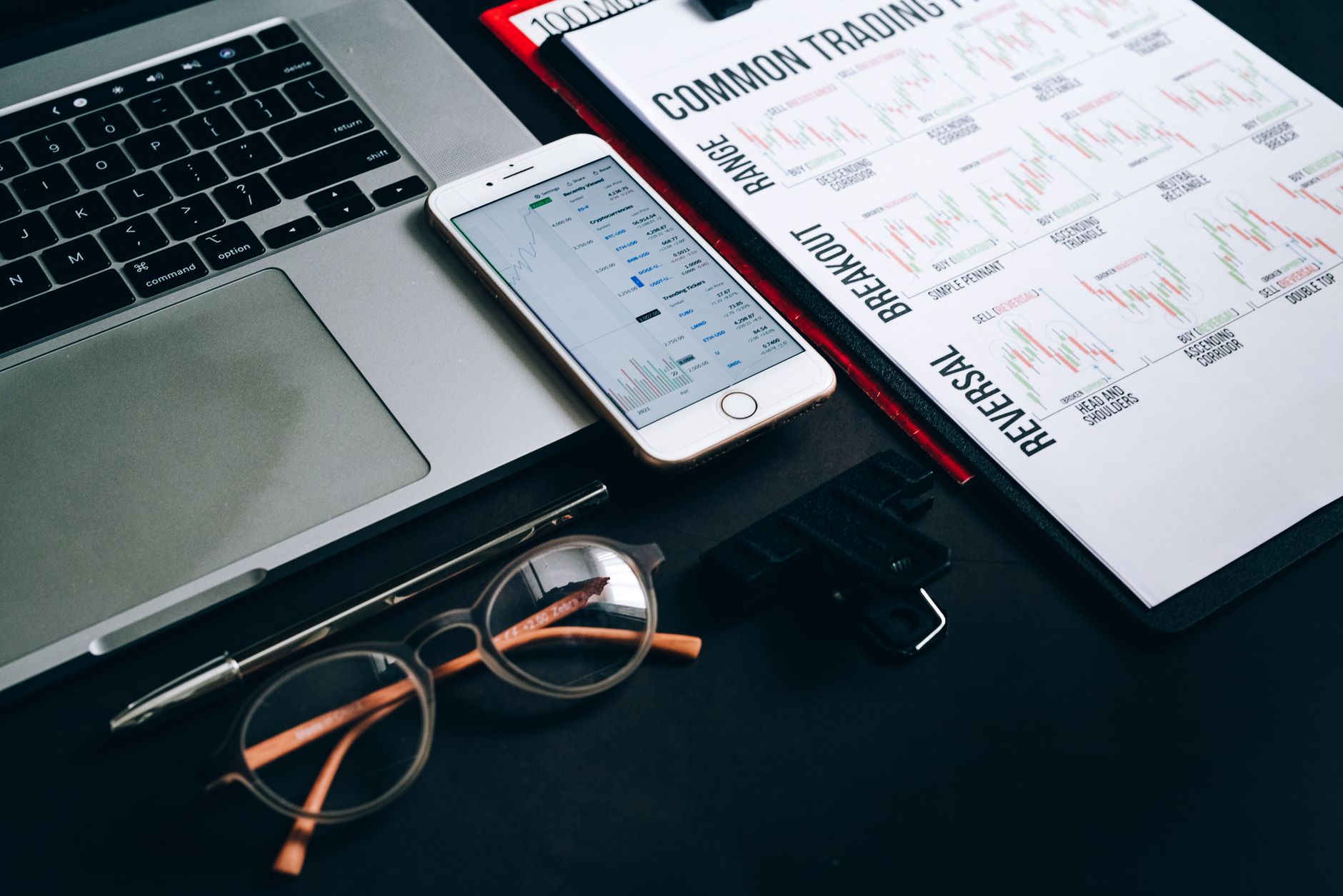 Financial analyst reviewing investment charts and data on a desk