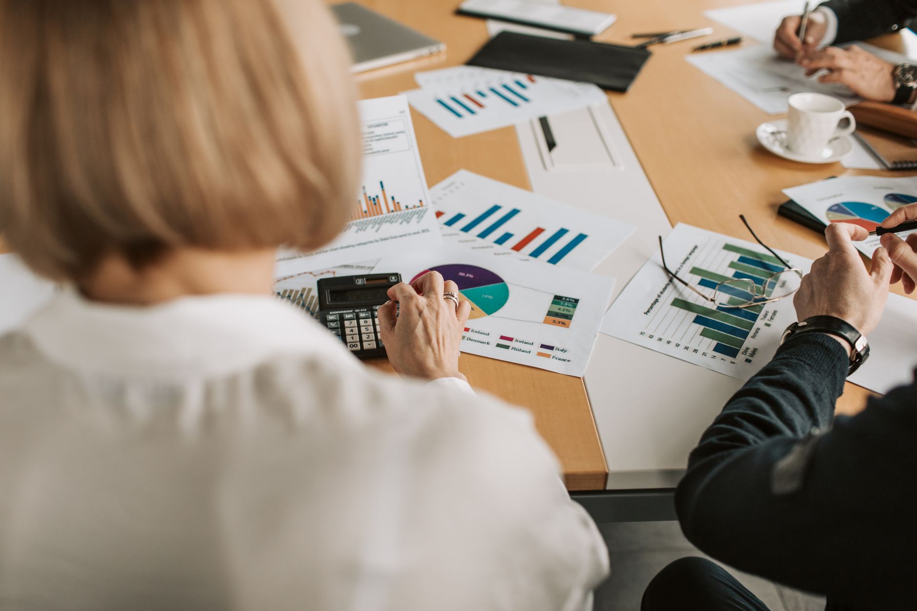 Business professionals reviewing financial documents in a corporate office meeting