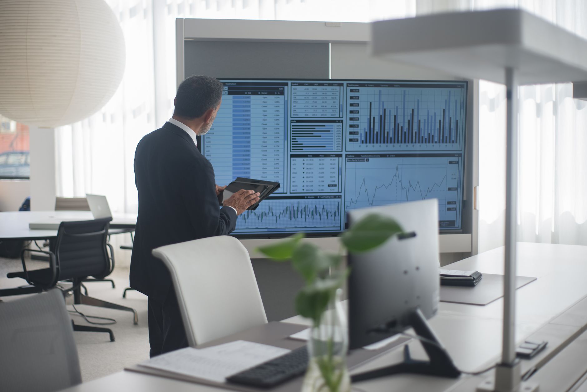Modern fintech office interior with screens displaying financial data