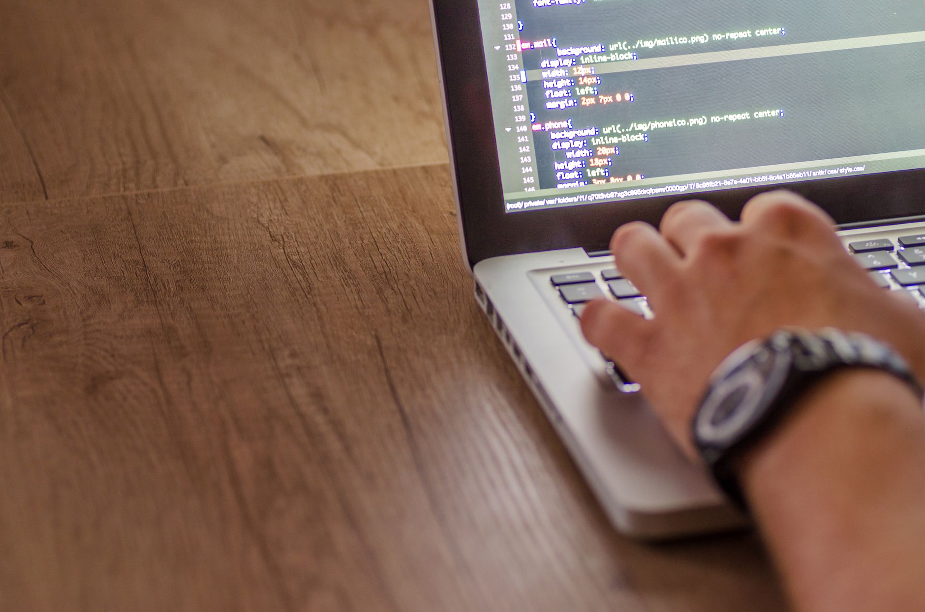 Software developer working on code at a laptop computer