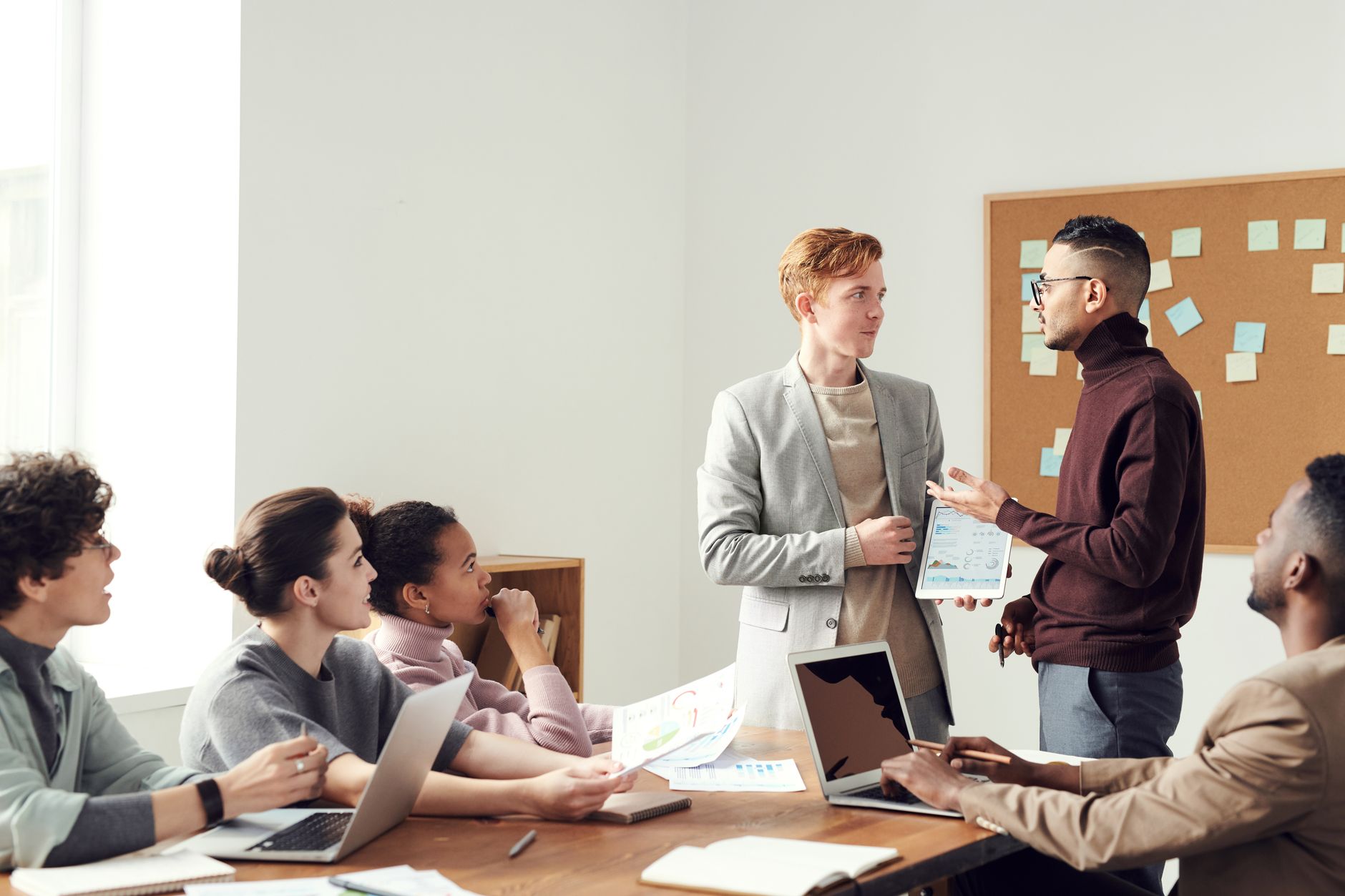 Business executives gathered around a table reviewing charts during a strategy meeting