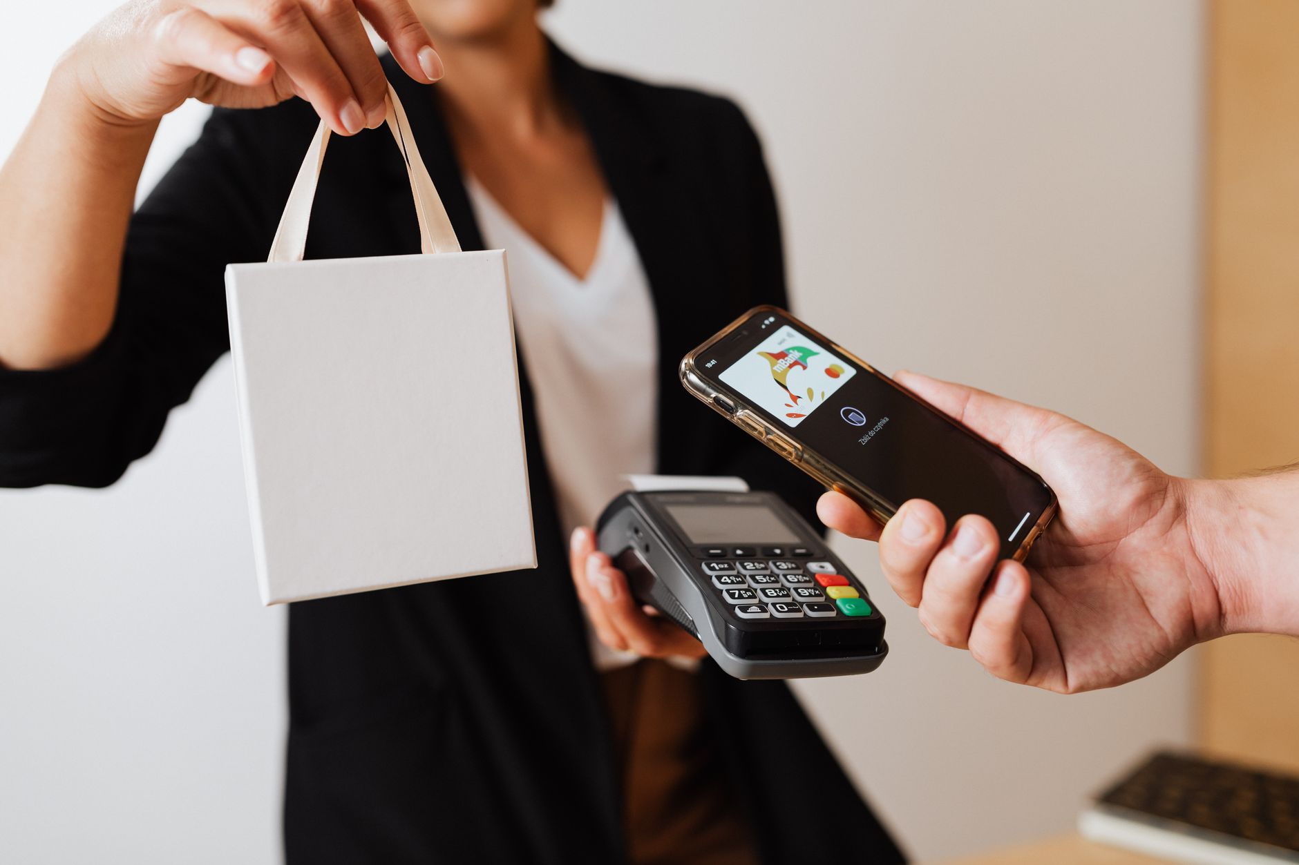 Hand holding a smartphone displaying a digital wallet interface