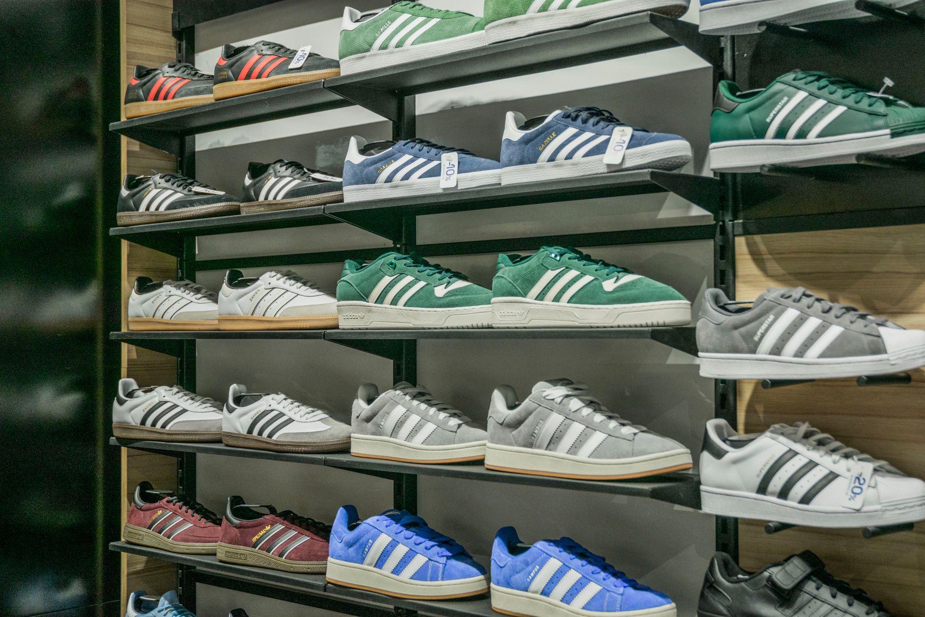 Interior of a retail sneaker store with shoes displayed on shelves under bright lighting