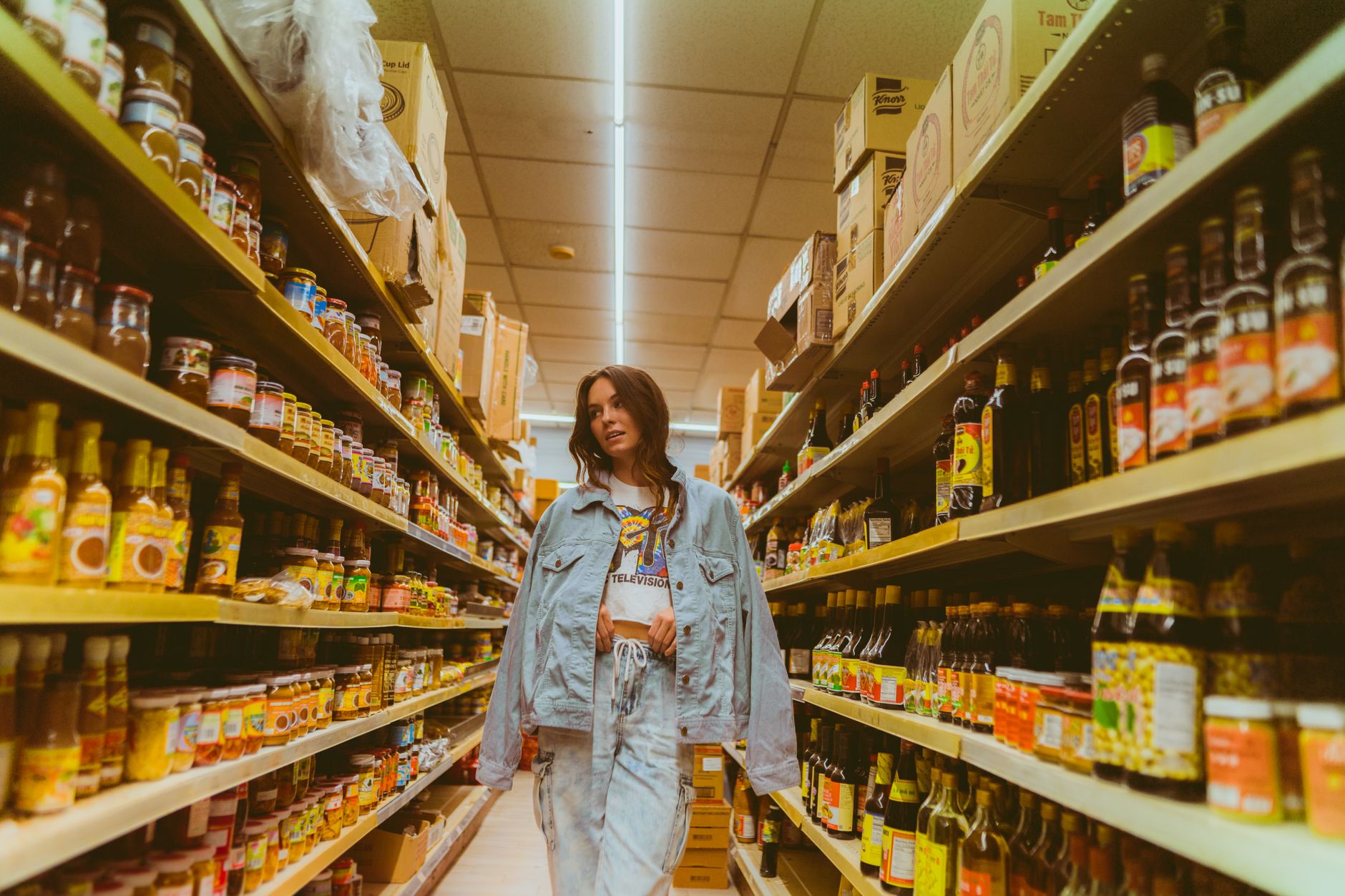 Bright supermarket aisle with shelves stocked with grocery products