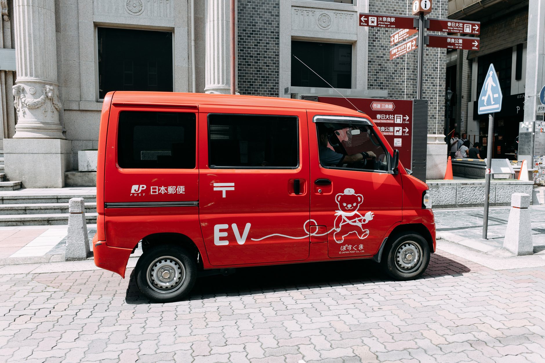 An electric delivery van parked on a city street representing fleet EV operations