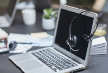 Business professionals working with AI tools on laptops in a modern office environment