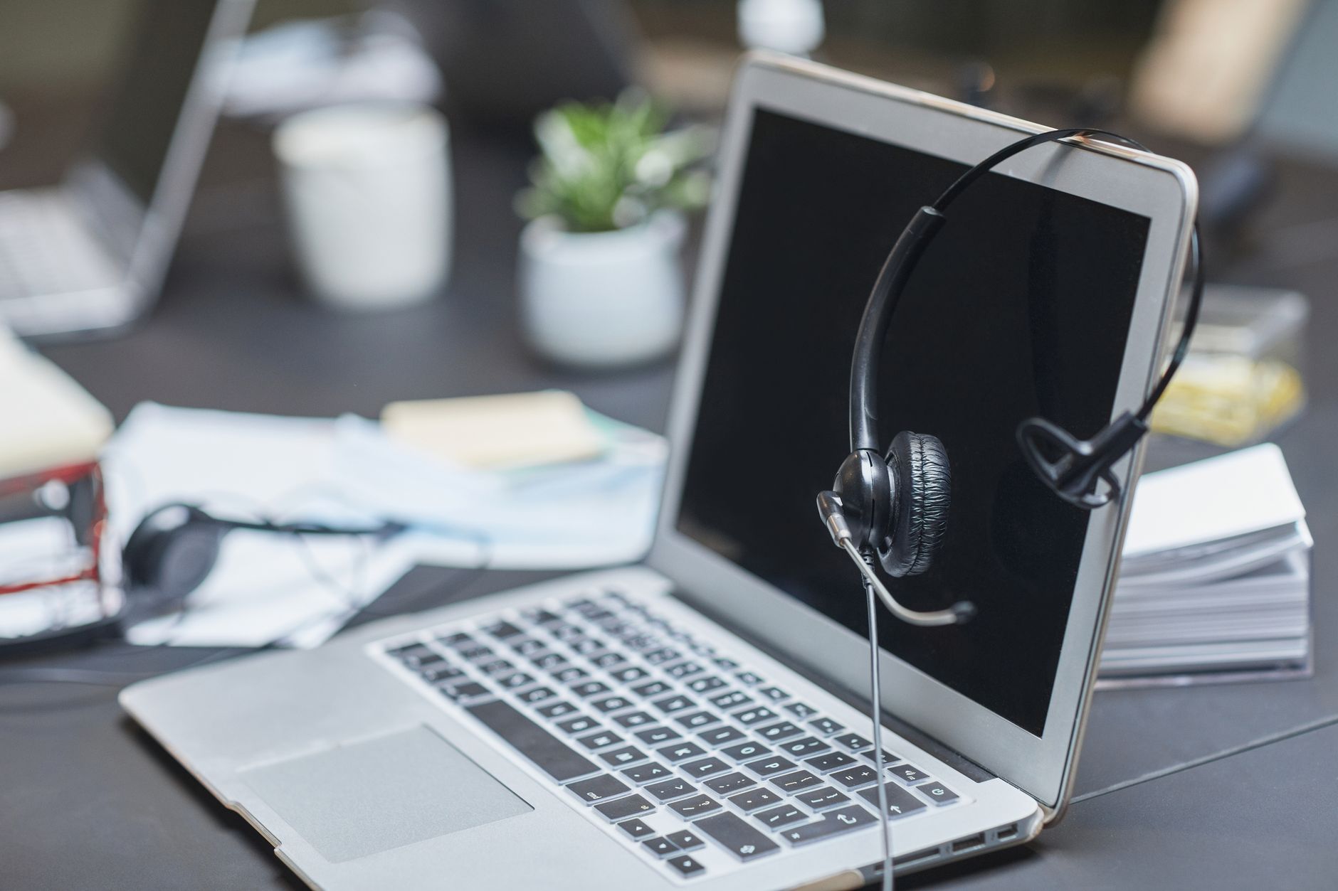 Business professionals working with AI tools on laptops in a modern office environment
