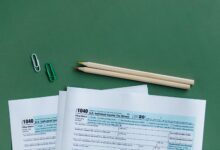 Person sitting at a desk organizing tax documents and forms during tax season