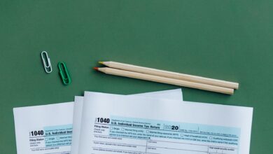 Person sitting at a desk organizing tax documents and forms during tax season