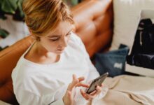 Person browsing a shopping app on a smartphone with product listings visible on screen
