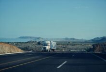 A semi-truck driving along an open highway representing freight logistics and trucking industry