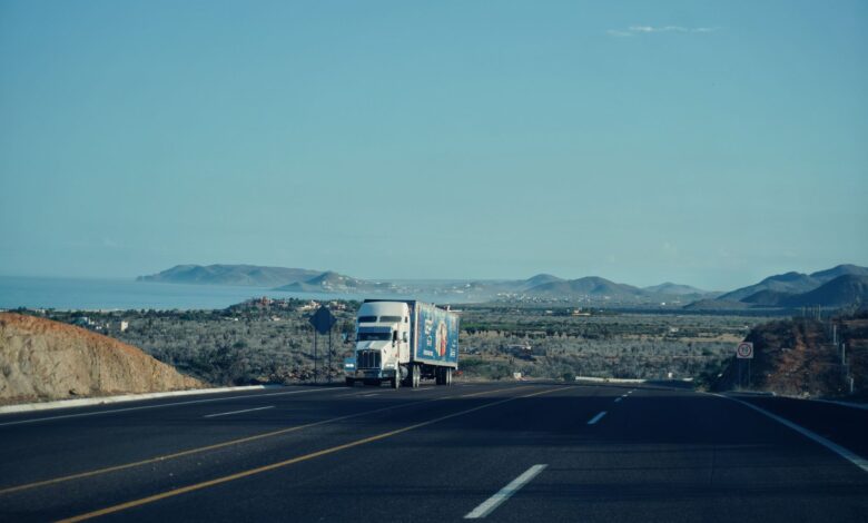 A semi-truck driving along an open highway representing freight logistics and trucking industry