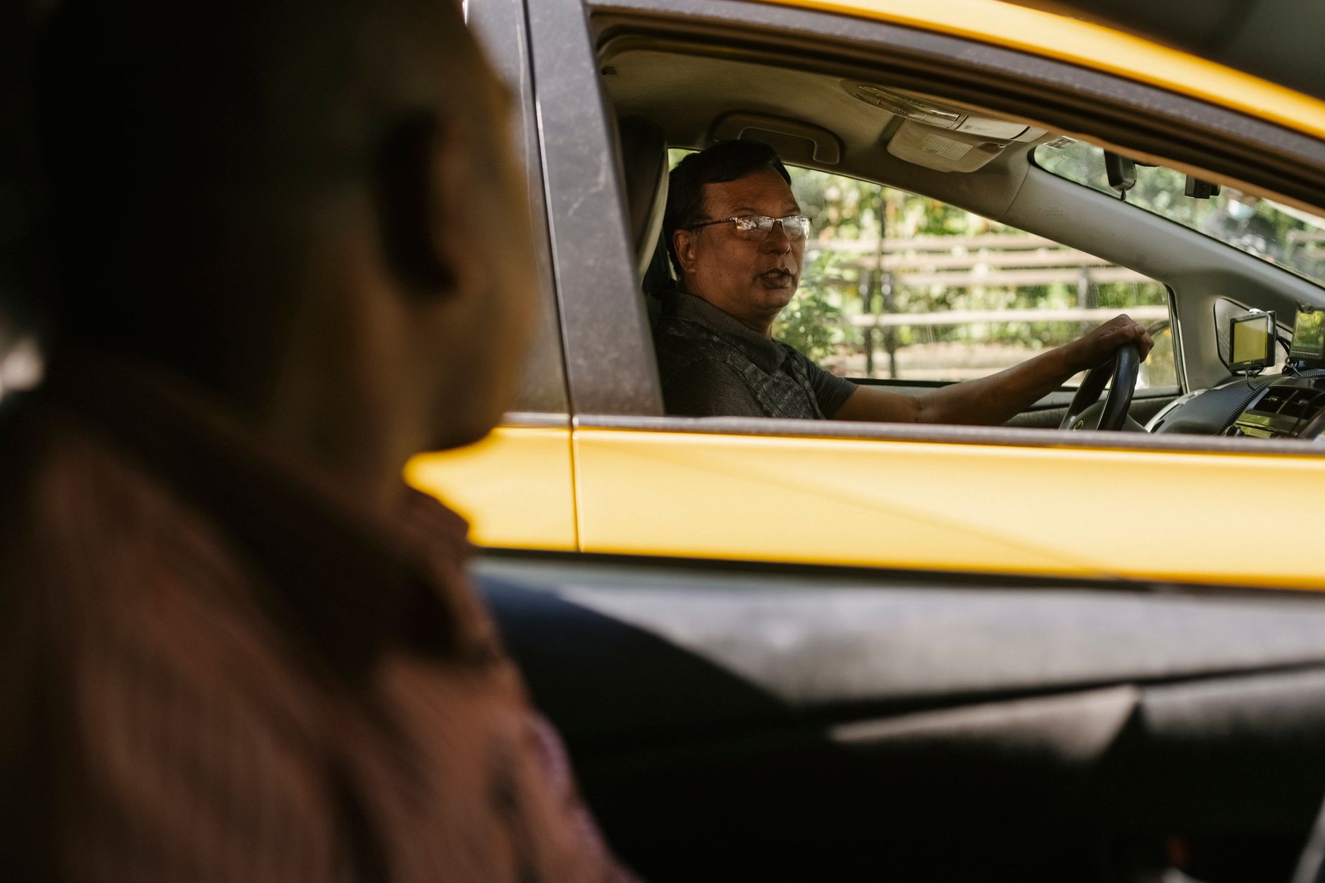 A rideshare driver in a vehicle, representing the human workforce affected by autonomous vehicle partnerships