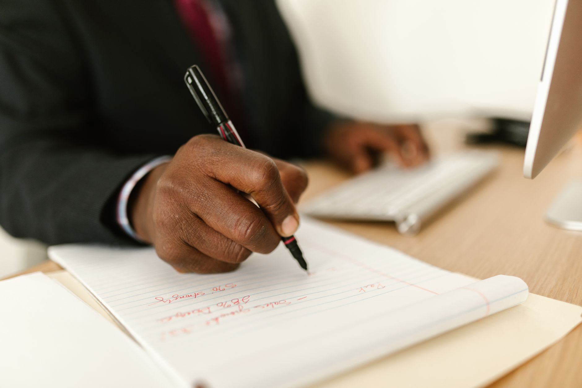 Professional taking notes on a tablet during a business meeting