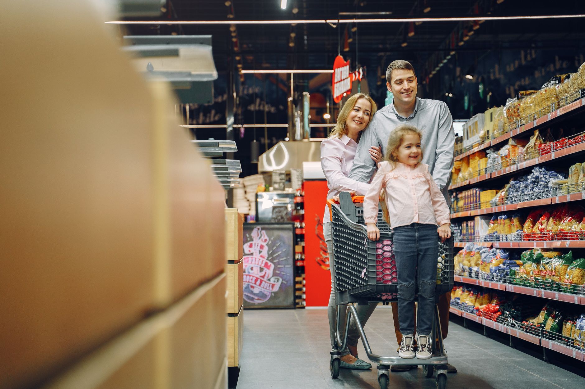 Wide shot of a supermarket aisle with shelves stocked with consumer packaged goods