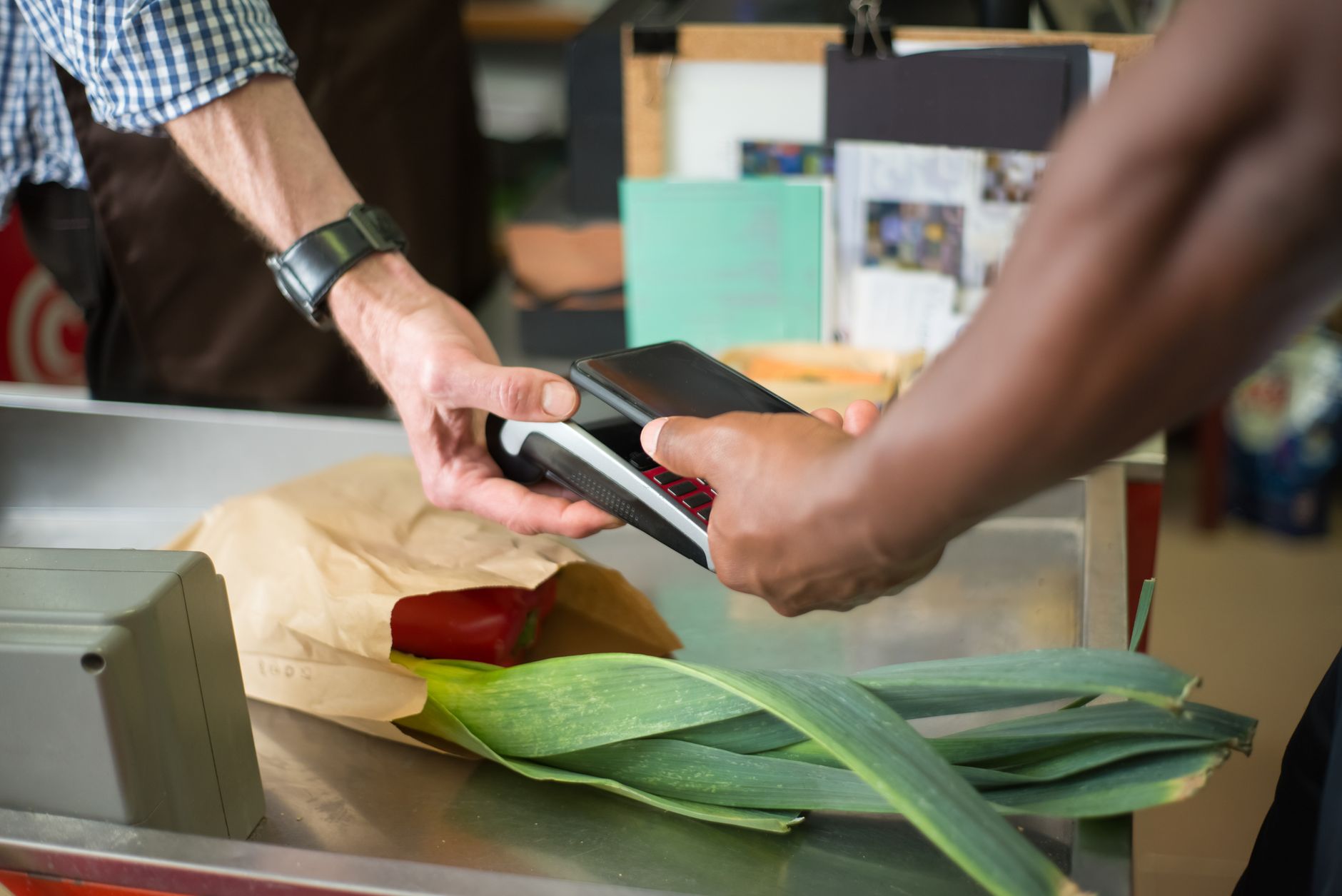 Shopper completing a contactless debit card transaction at a grocery store checkout