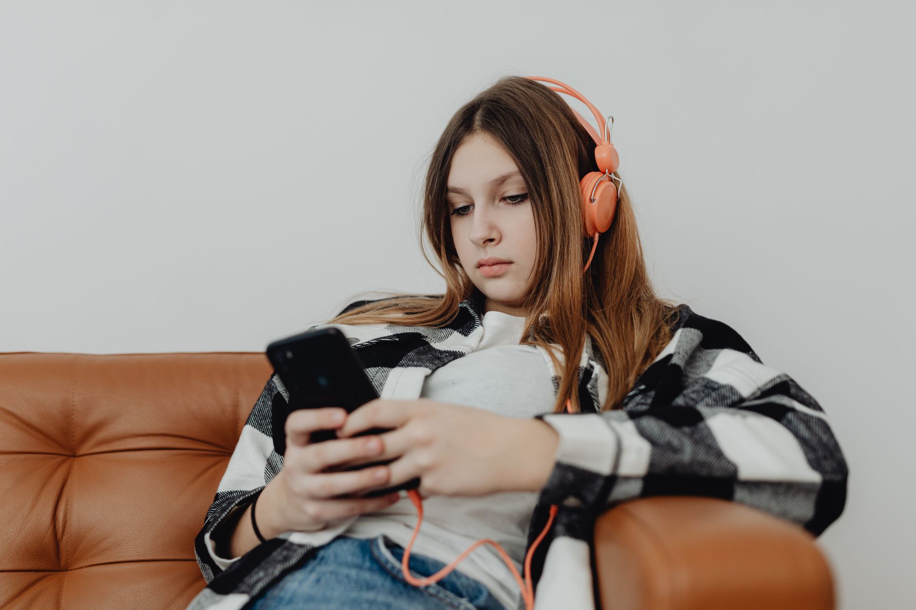 Person wearing headphones using a music streaming app on a smartphone