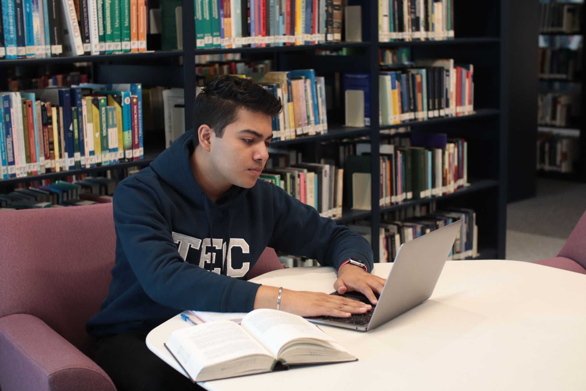 University student using a laptop for research and note-taking