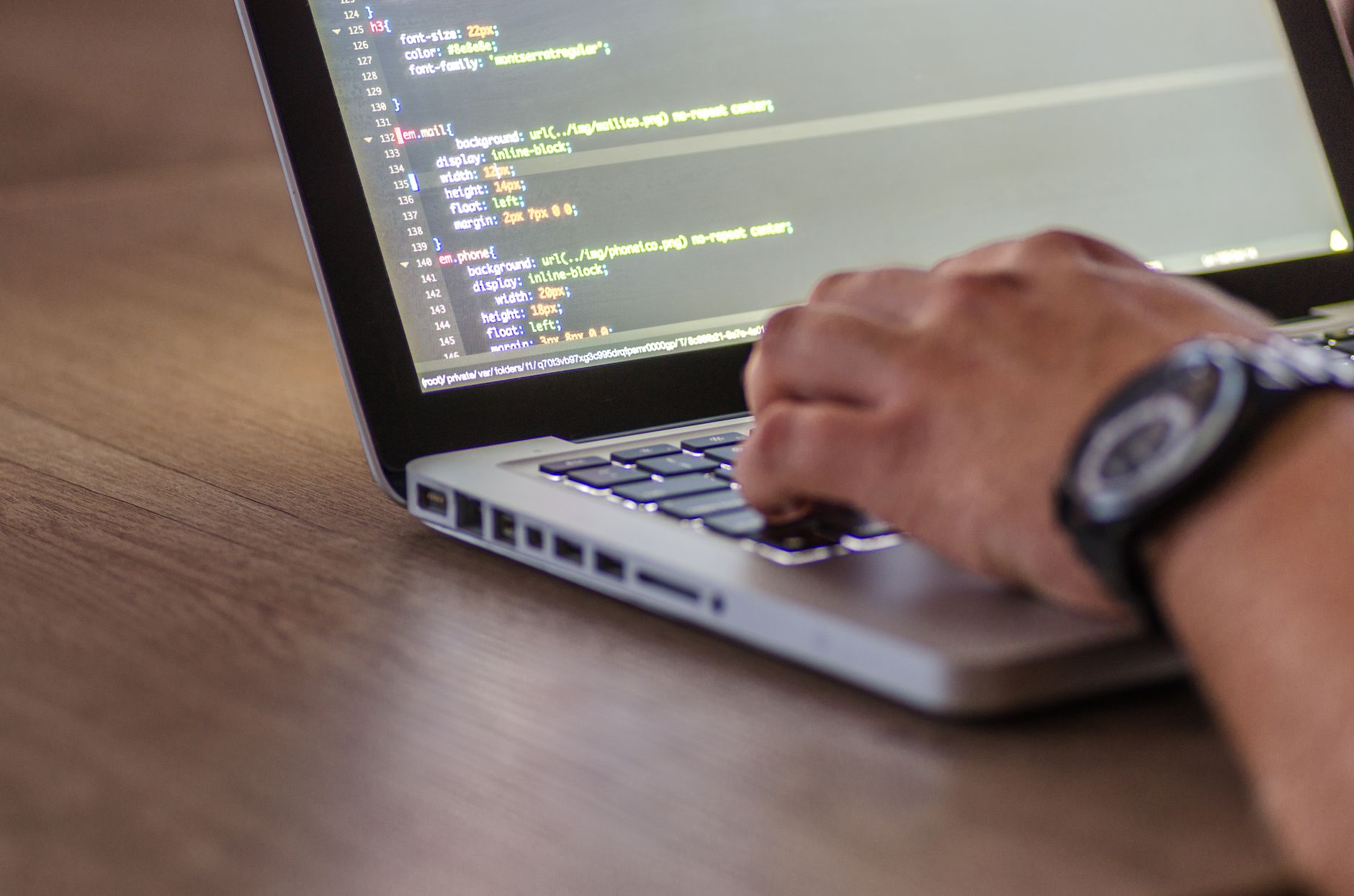 Developer reviewing software integrations and code on a laptop in a business setting