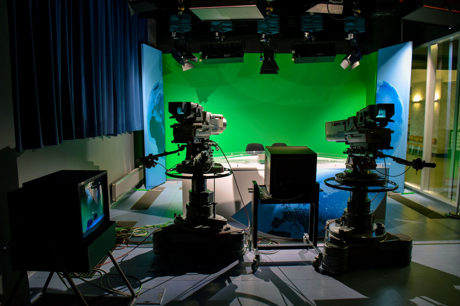 Professional sports broadcasting studio with multiple screens showing live coverage