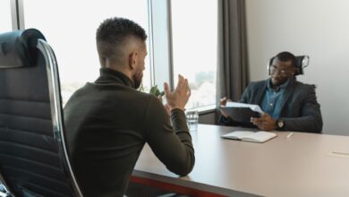 A recruiter reviewing candidate profiles on a laptop in a modern office environment