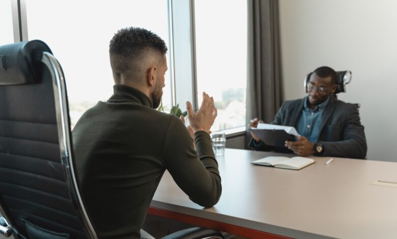 A recruiter reviewing candidate profiles on a laptop in a modern office environment