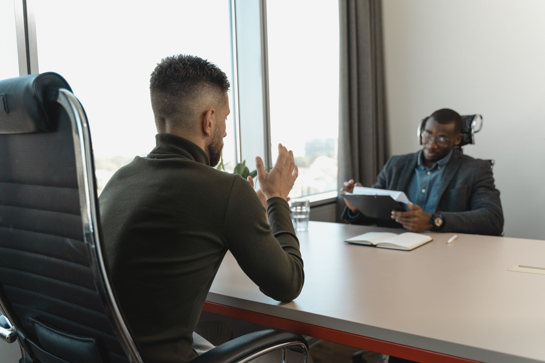 A recruiter reviewing candidate profiles on a laptop in a modern office environment