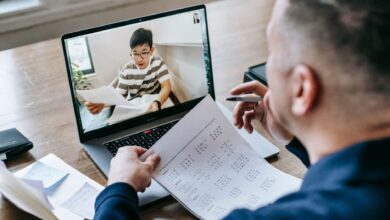 Professional using video conferencing software on a laptop in a modern office setting