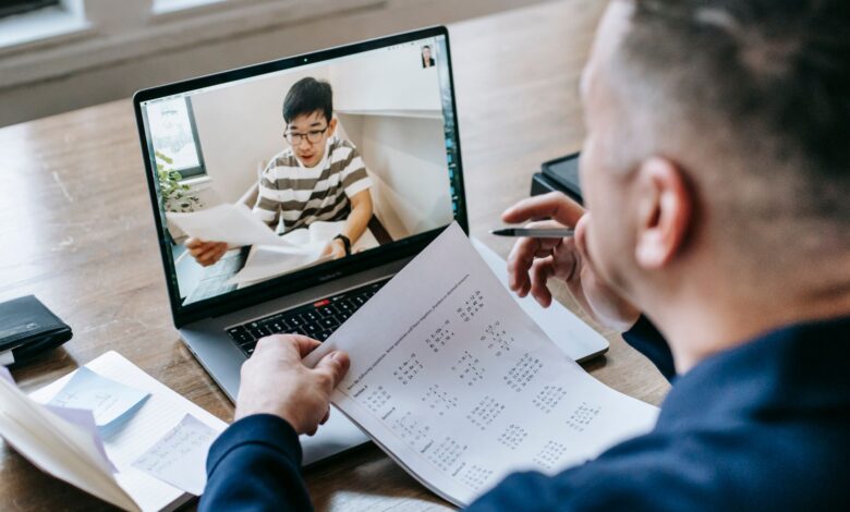 Professional using video conferencing software on a laptop in a modern office setting