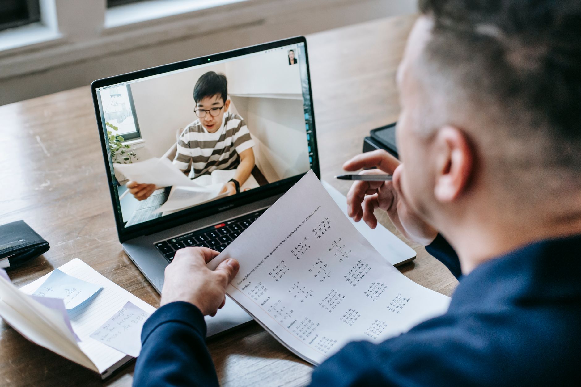 Professional using video conferencing software on a laptop in a modern office setting