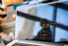 Developer working on code on a laptop screen in a modern workspace