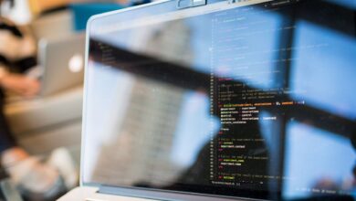 Developer working on code on a laptop screen in a modern workspace