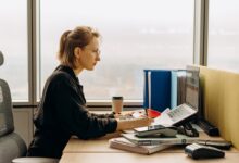 A person using accounting software on a laptop at a small business desk