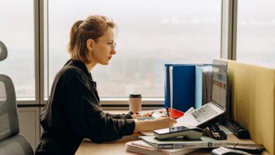 A person using accounting software on a laptop at a small business desk