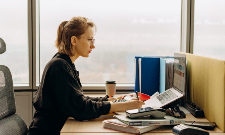 A person using accounting software on a laptop at a small business desk