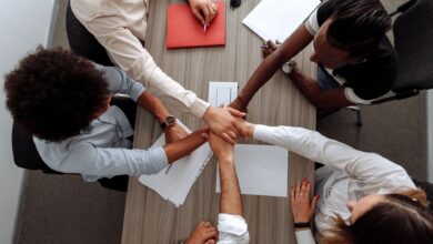 A team of colleagues collaborating around a shared screen in a modern office workspace