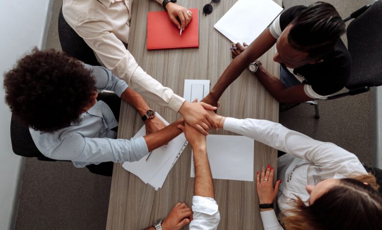 A team of colleagues collaborating around a shared screen in a modern office workspace